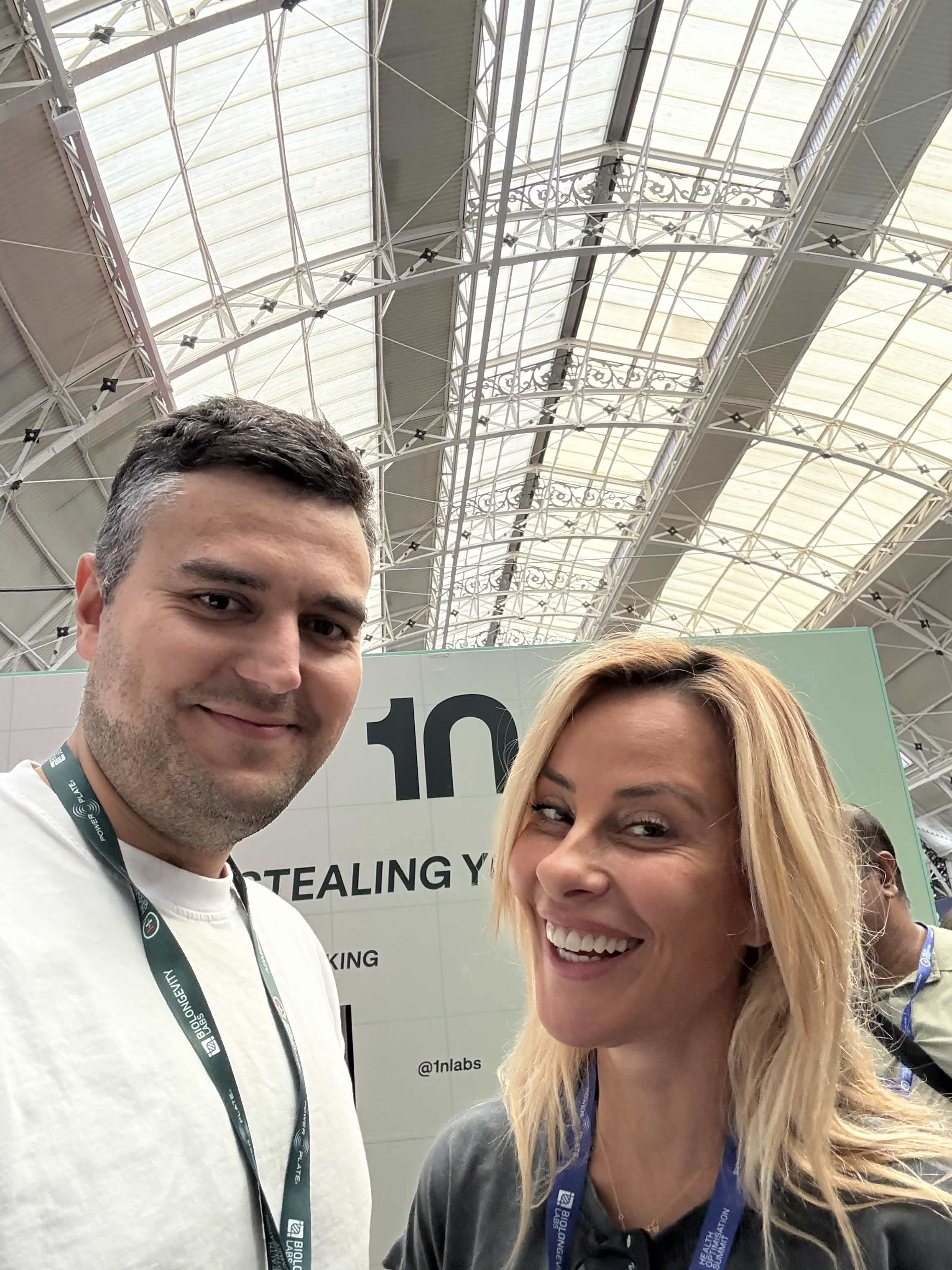 An xHeal team member at the Summit stand with an attendee in front of the 1n exhibitor booth